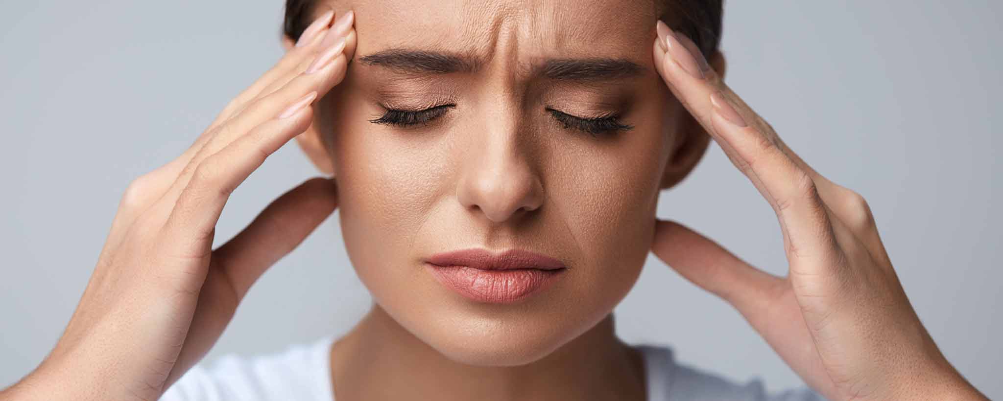 'Woman holding head with migraine'