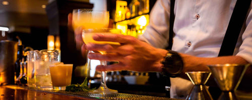 Mixologists pouring drinks at bar