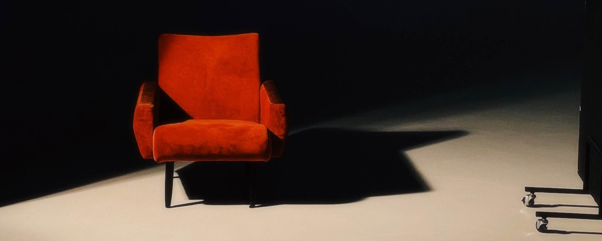 'Red chair in dark room'