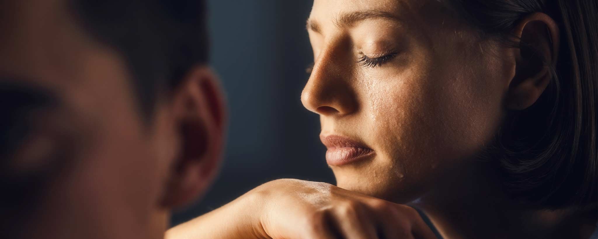 'A sad female cries while a man looks away.'
