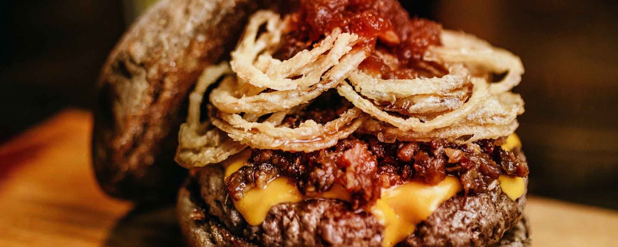 'Beef burger with chili and fried onions'