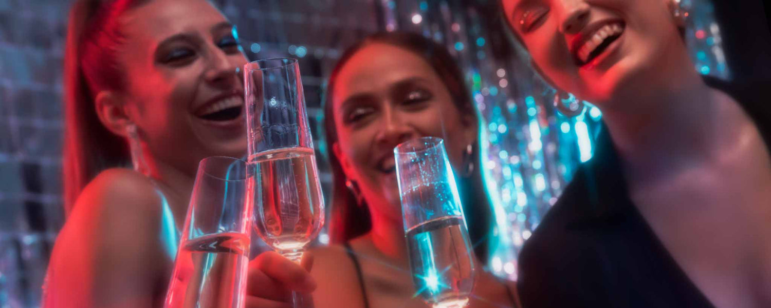 Three young ladies are partying with champagne.