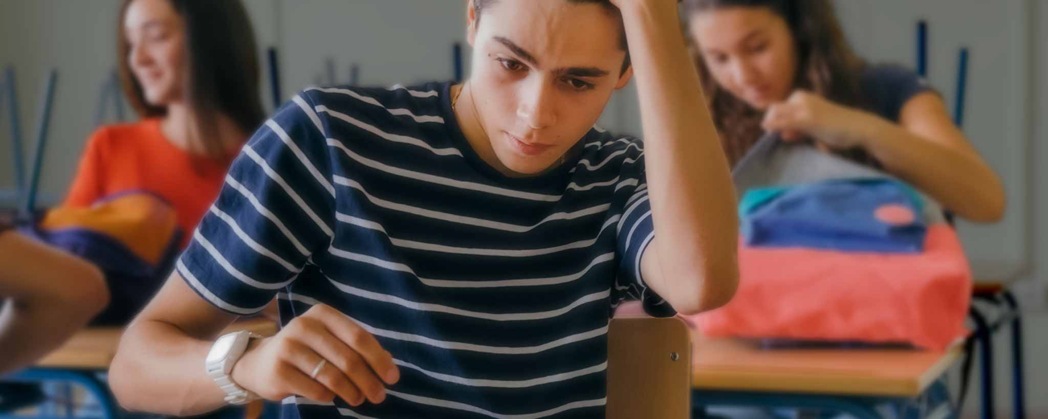 'A stressed male classroom student.'