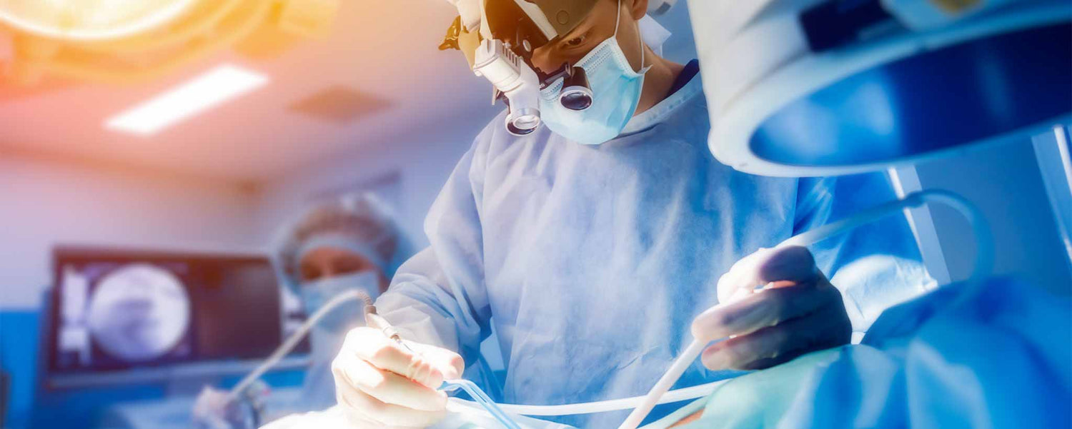 A doctor performs surgery in an operating room.