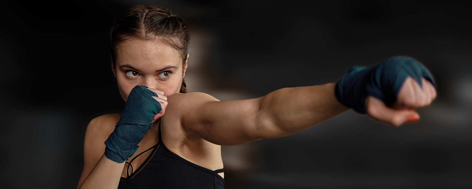 An intense young female practices punching in the air.